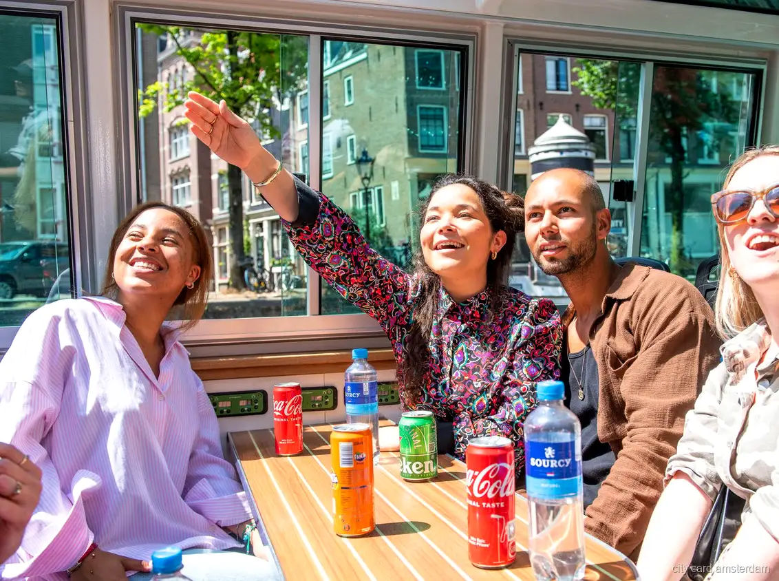 Passengers on the open rear deck of an Amsterdam canal cruise boat